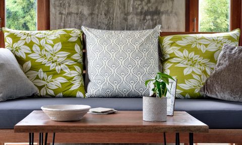 Living room sofa with green and white pillows with a wood coffee table