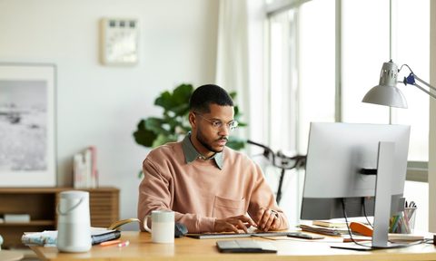 Man working at his computer on a desk in his home office