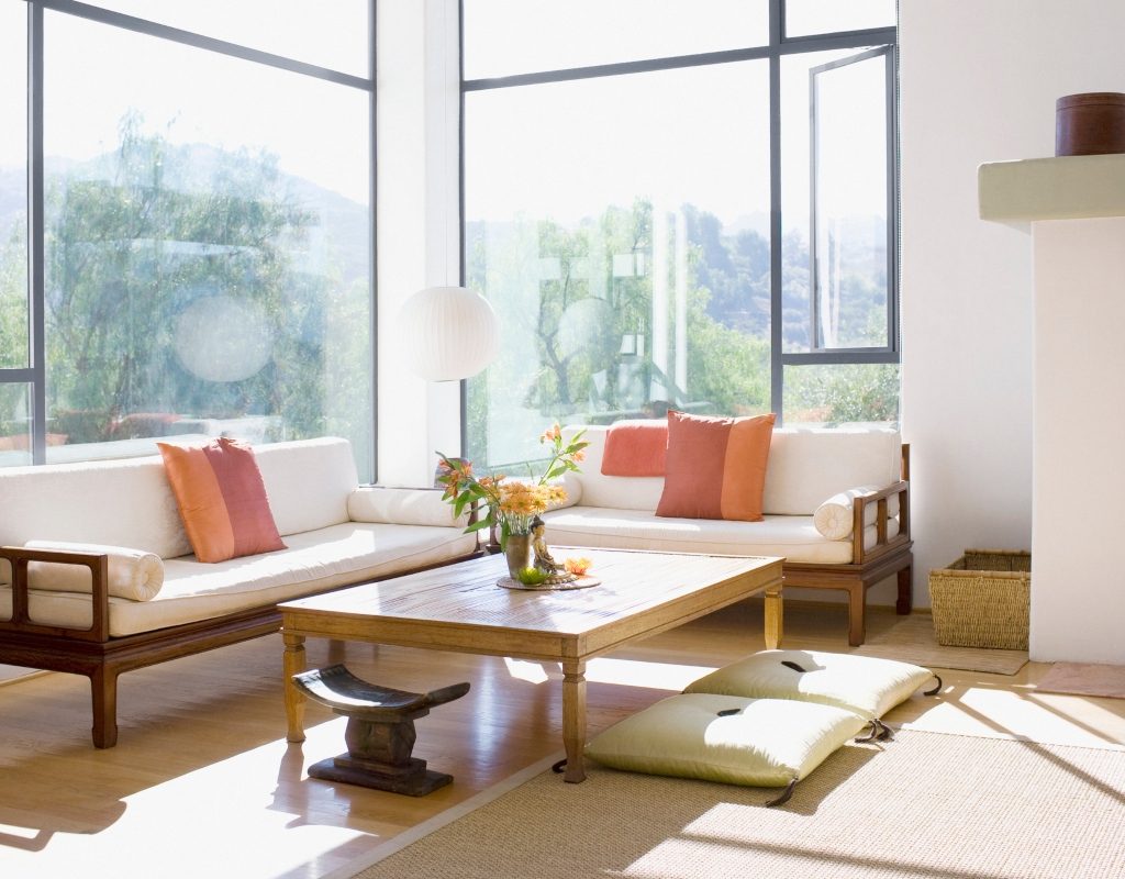 minimal and modern living room with wood coffee table and pink cushions on sofa