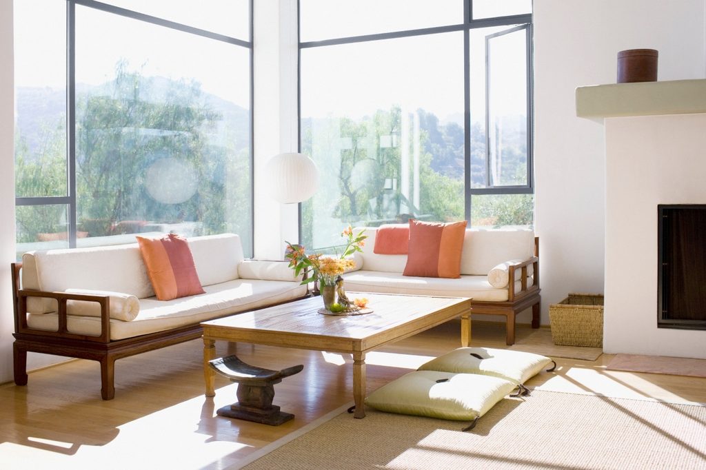 minimal and modern living room with wood coffee table and pink cushions on sofa
