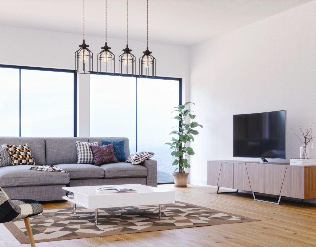 modern living room with grey sofa plant decor and wood tones