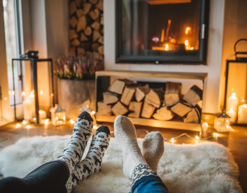 people cozying up to the fire by a fireplace in a living room