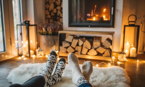 people cozying up to the fire by a fireplace in a living room