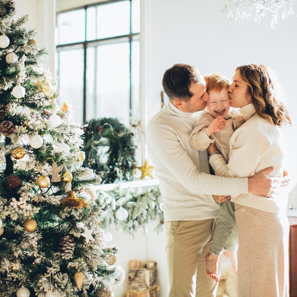 Family posing next to a Christmas tree