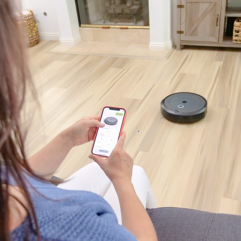 woman using phone to control robot vacuum