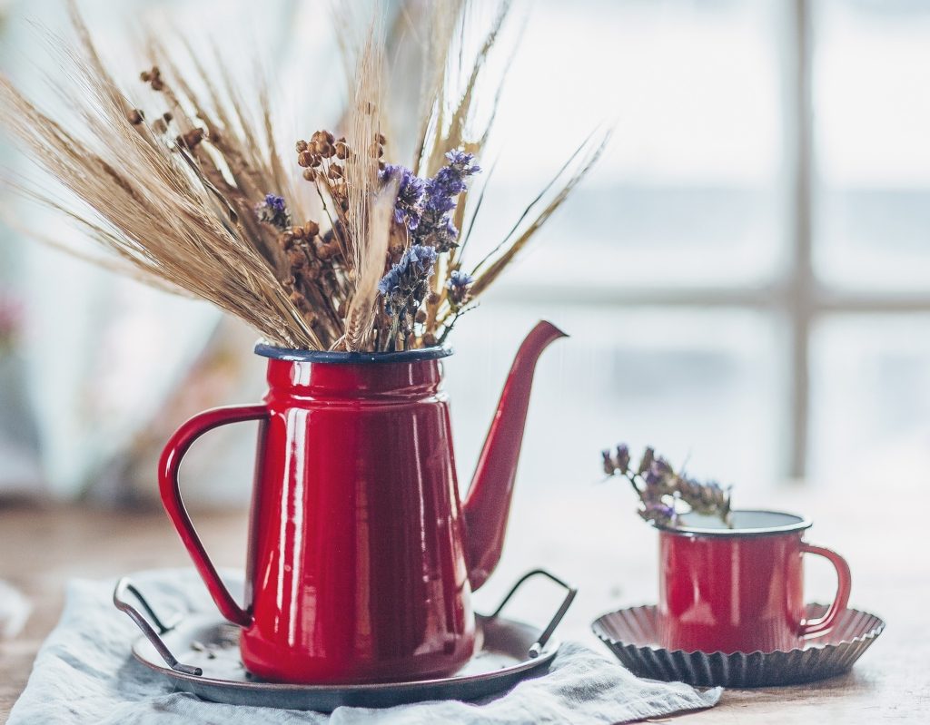 red teacup and kettle decor with brown grass in them