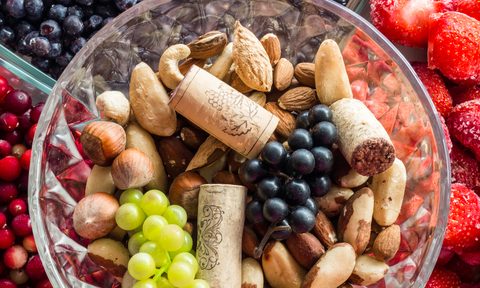 A fruit bowl with wine corks in it.