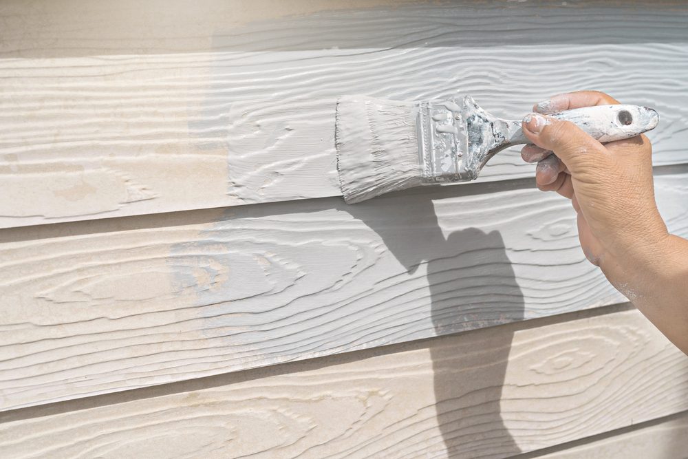 Hand painting wood paneling outdoors