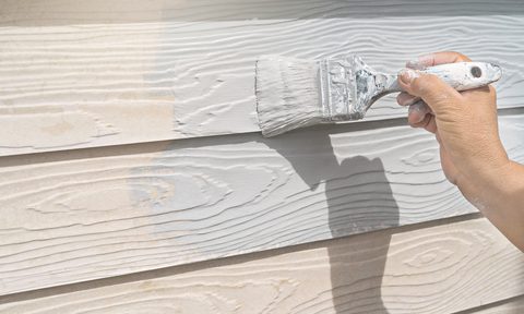 Hand painting wood paneling outdoors