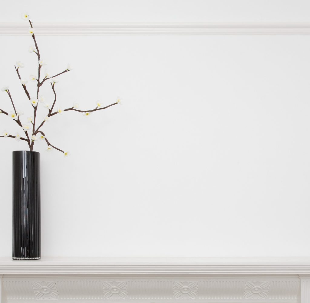 All-white mantle with black vase.