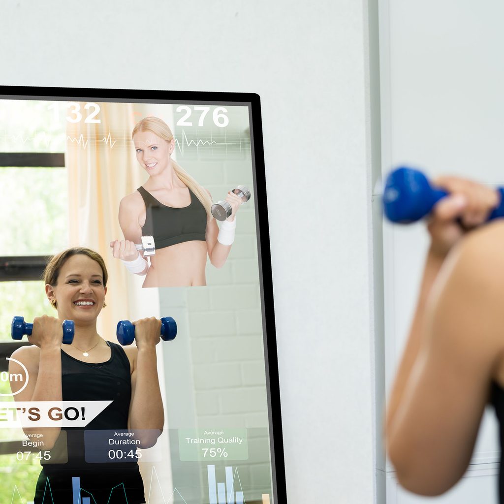 Woman exercising using a smart mirror