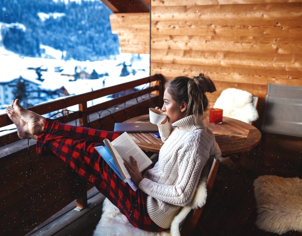 Woman sitting on a balcony during the winter