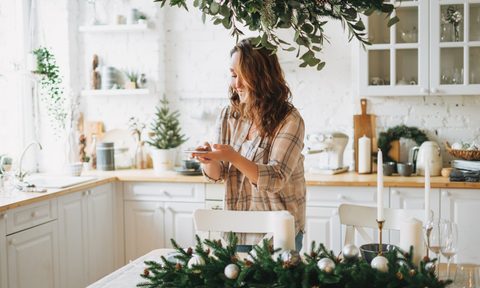 woman standing in a white kitchen with rustic winter decor