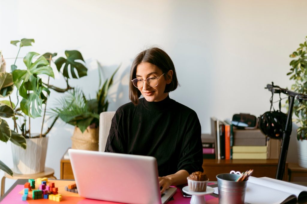 Woman working in home office surrounded by plants