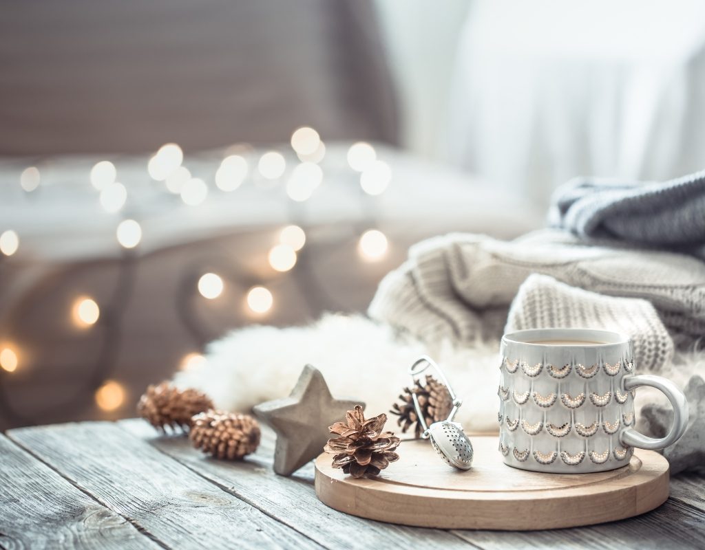 wood palette with ceramic mug pine cones and christmas lights