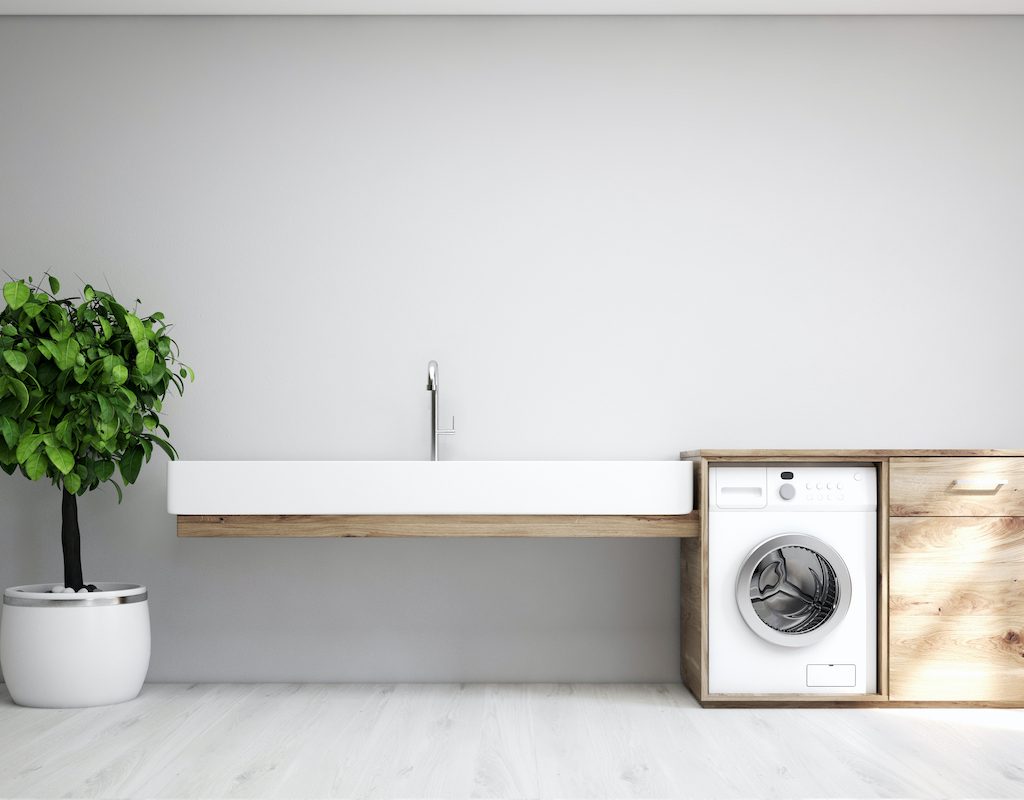 Gray laundry room interior with a sink and washing machine