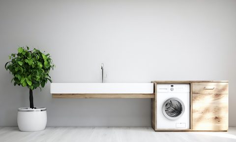 Gray laundry room interior with a sink and washing machine