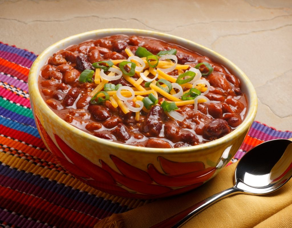 bowl of chili with cheese and onion toppings