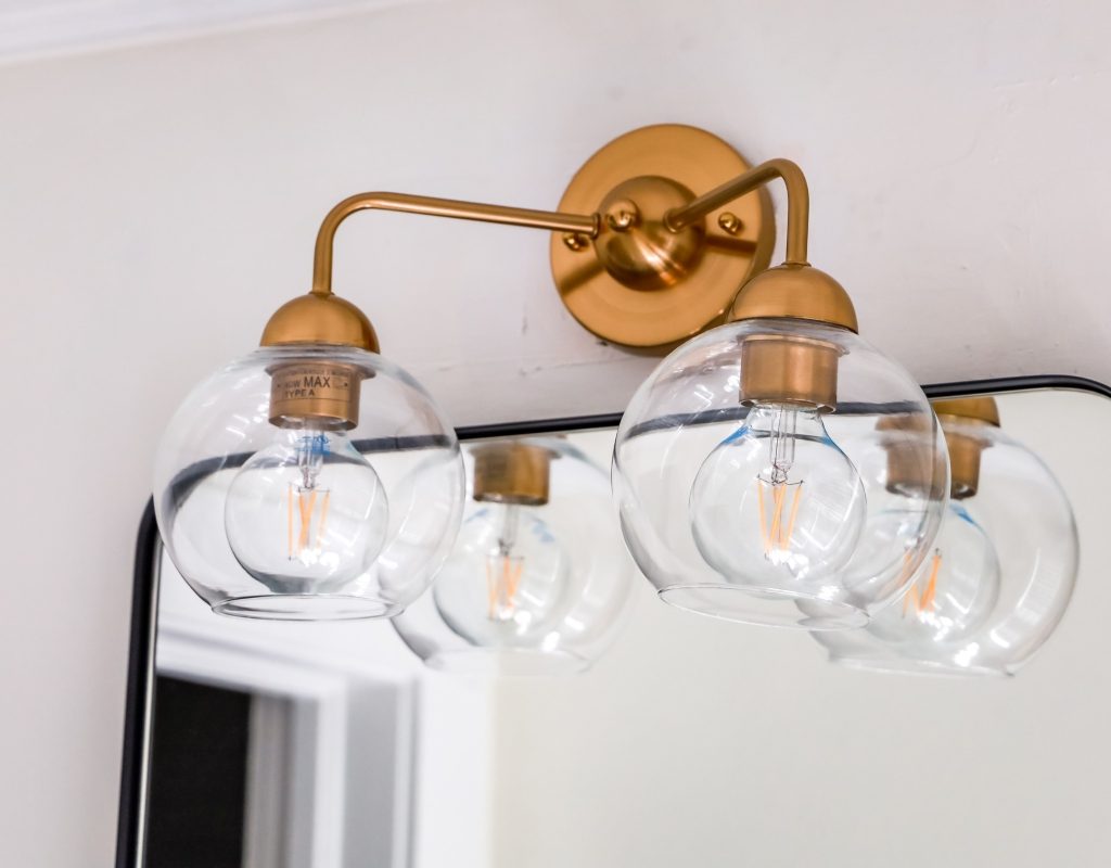 glass globe light fixture above mirror