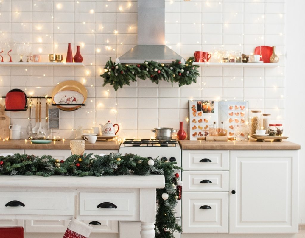 Kitchen with red and green winter color palette, garland, and fairy lights