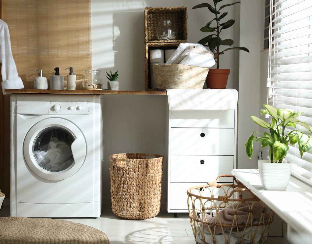 Bathroom with storage baskets, drawers, and a washing machine