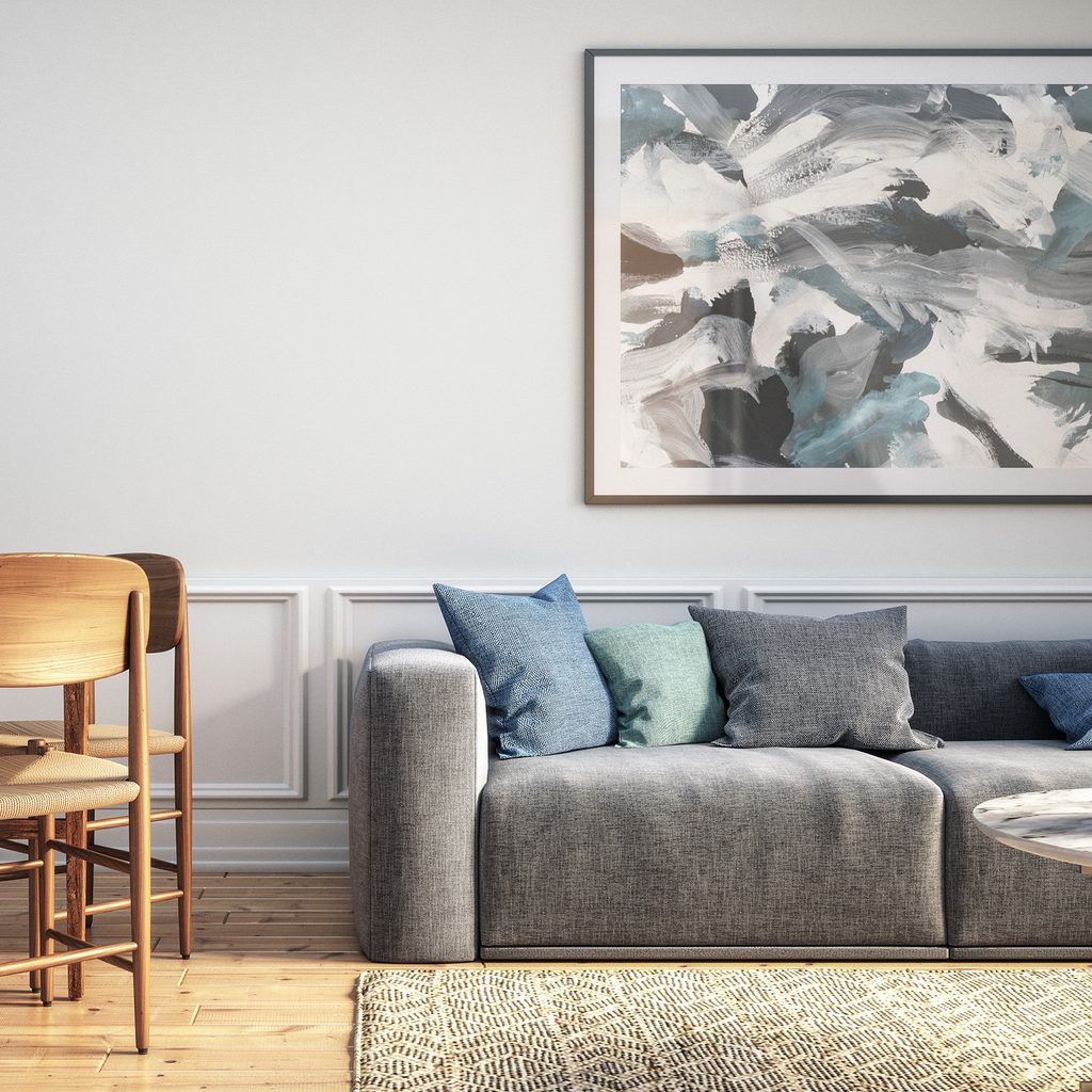 Living area with abstract art hanging over the couch