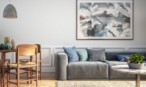 Living area with abstract art hanging over the couch