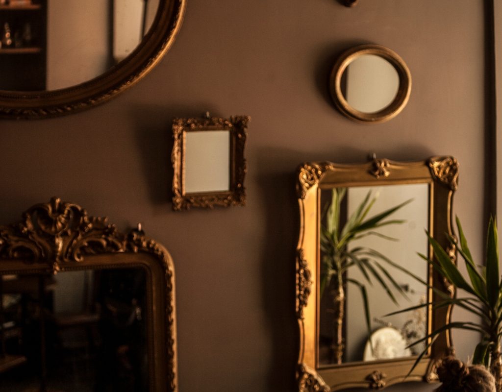 Multiple antique mirrors on gallery wall