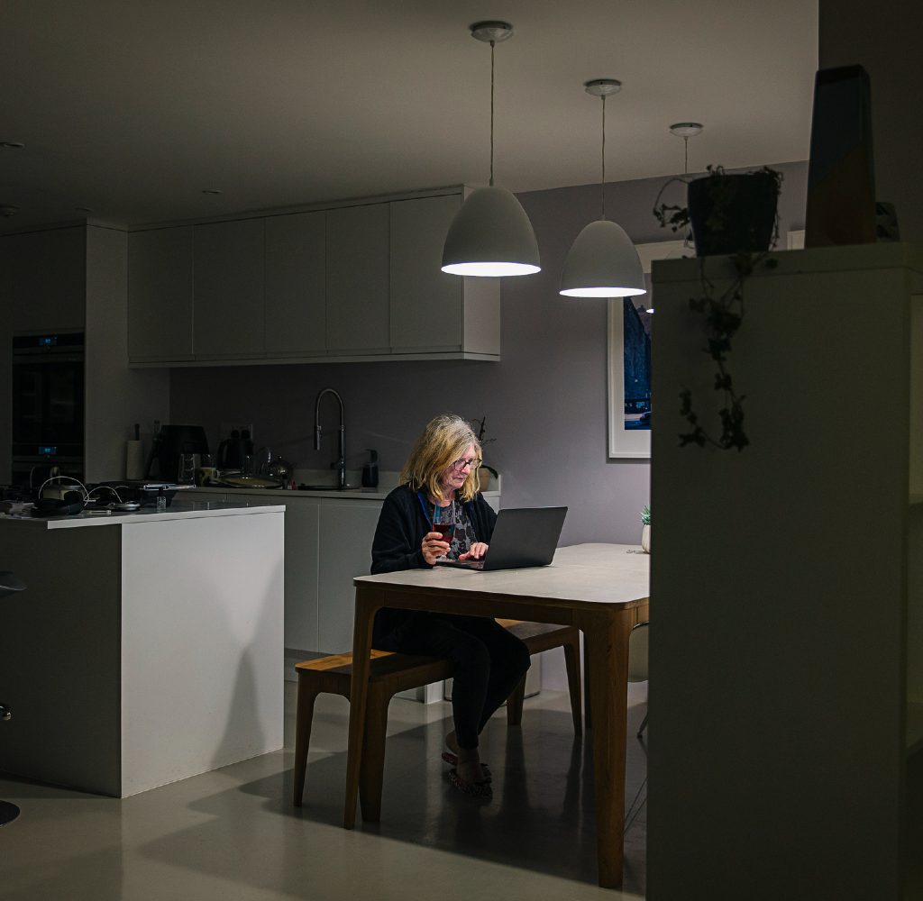 Woman working in home with open floorplan.