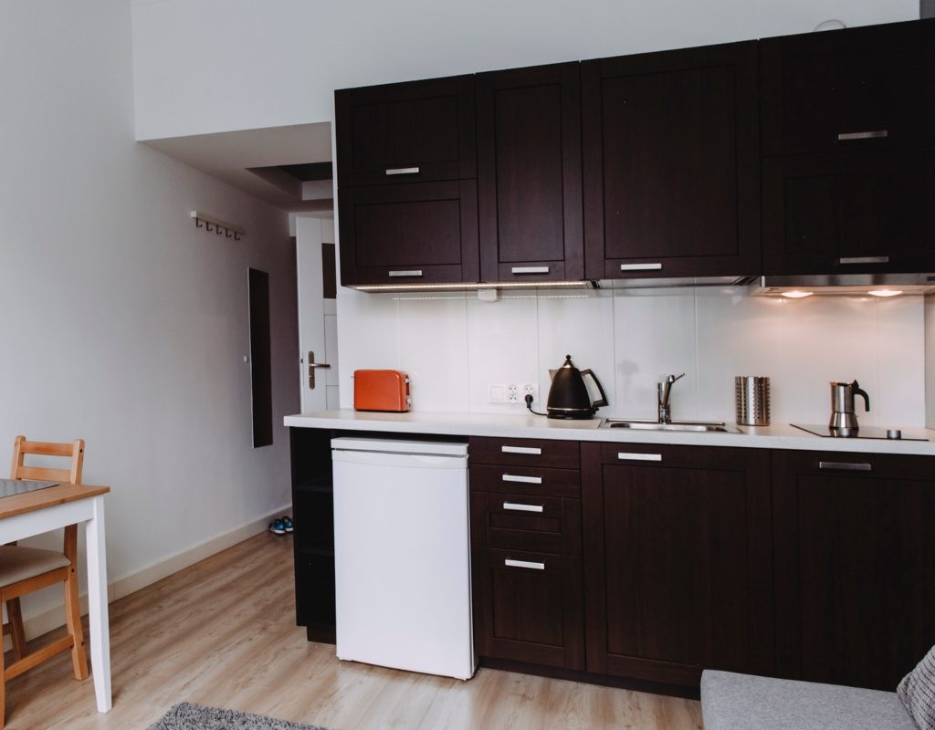 small kitchenette in basement with dark cabinets