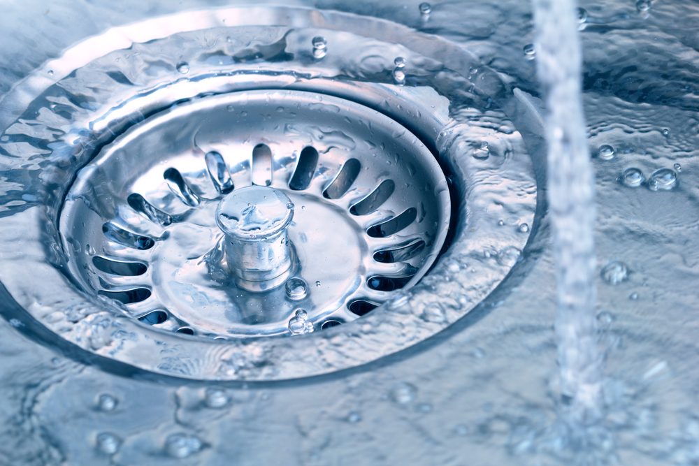Close up of water going down kitchen sink drain.