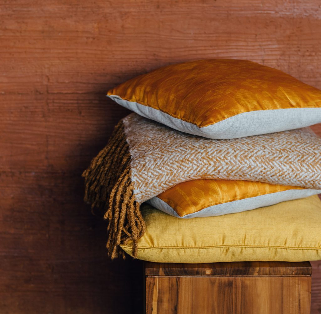 Gold pillows against terracotta wall
