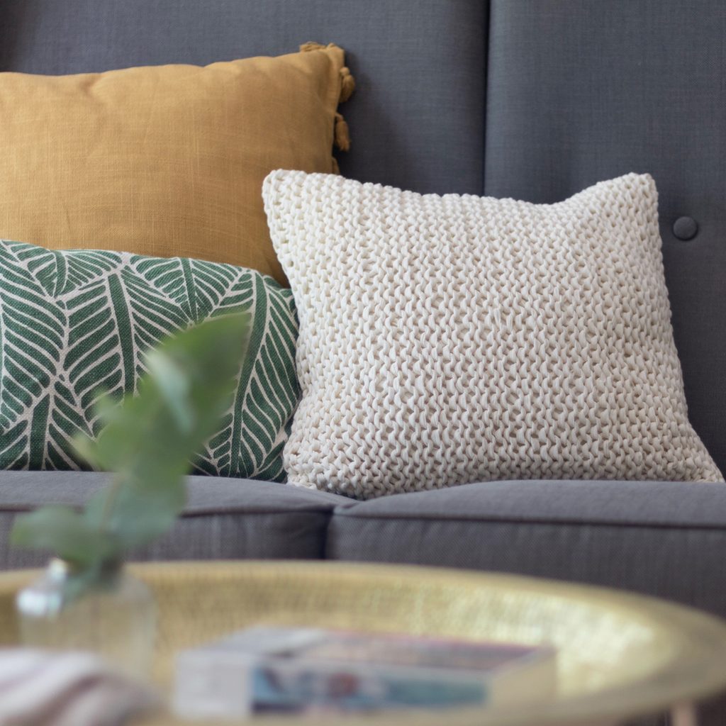Three throw pillows on a sofa