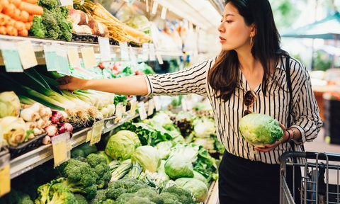 Woman choosing produce at a grocery store