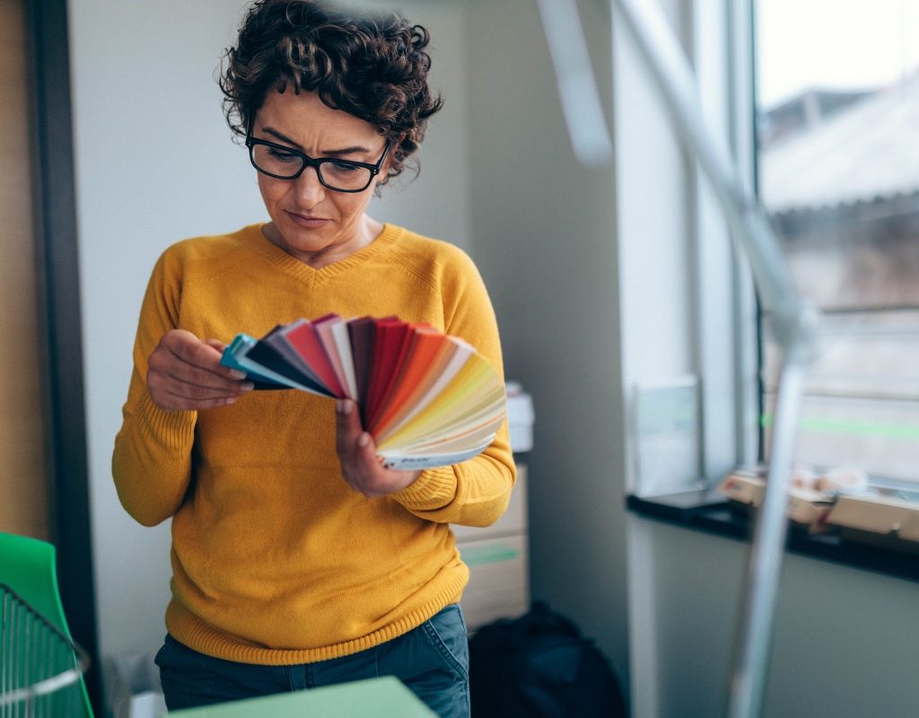 woman holding and looking at interior design color swatches