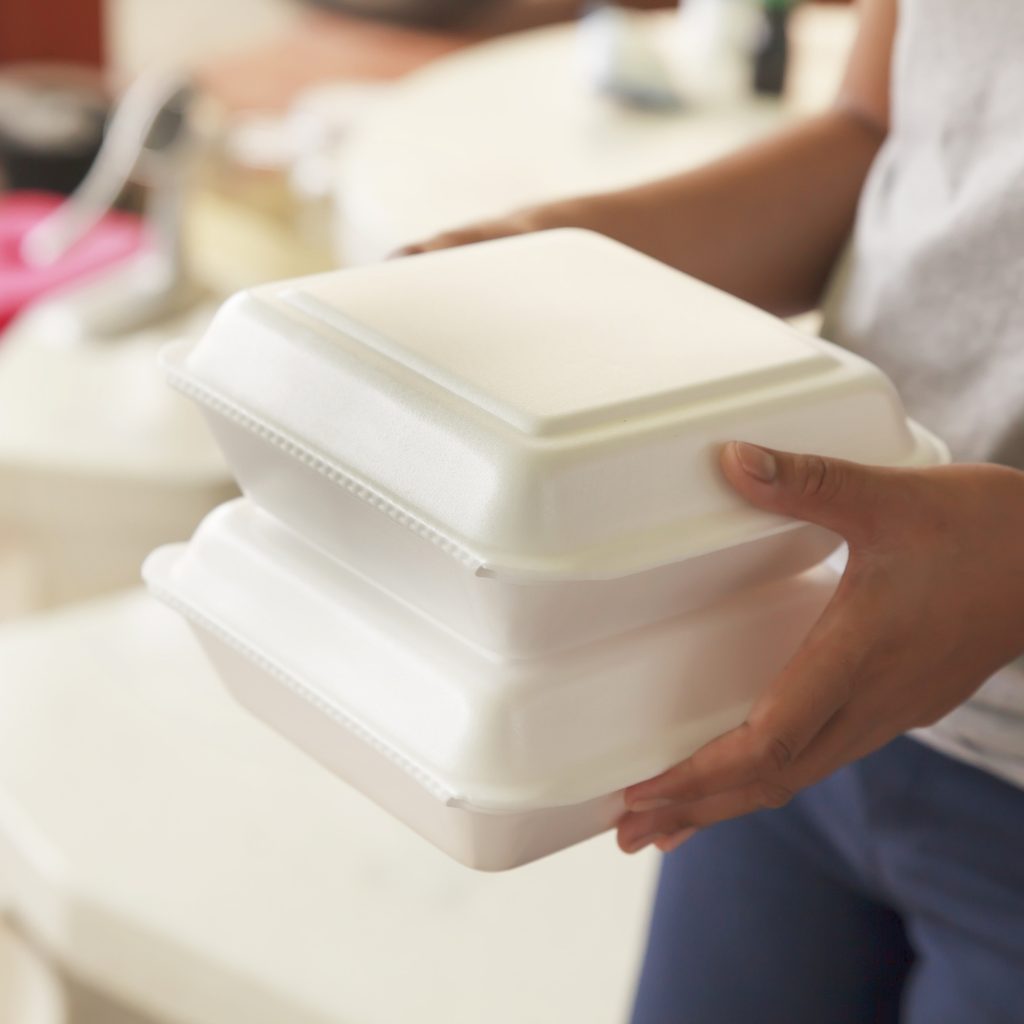 Person holding two Styrofoam containers