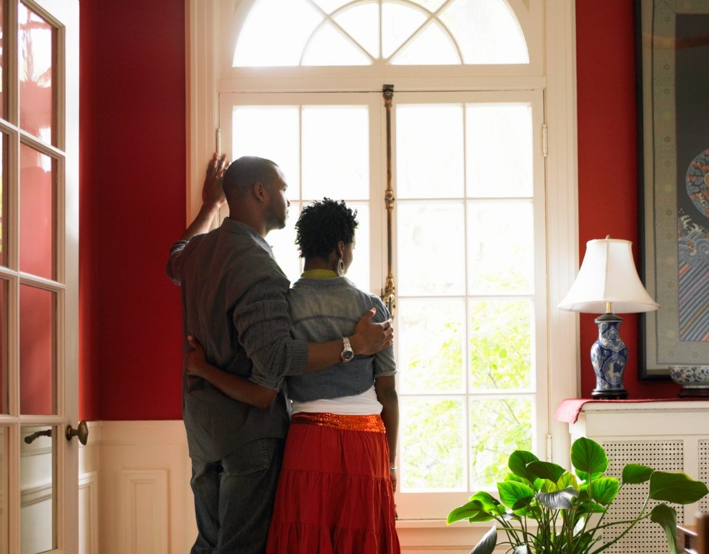 couple standing in front of window in a red painted room