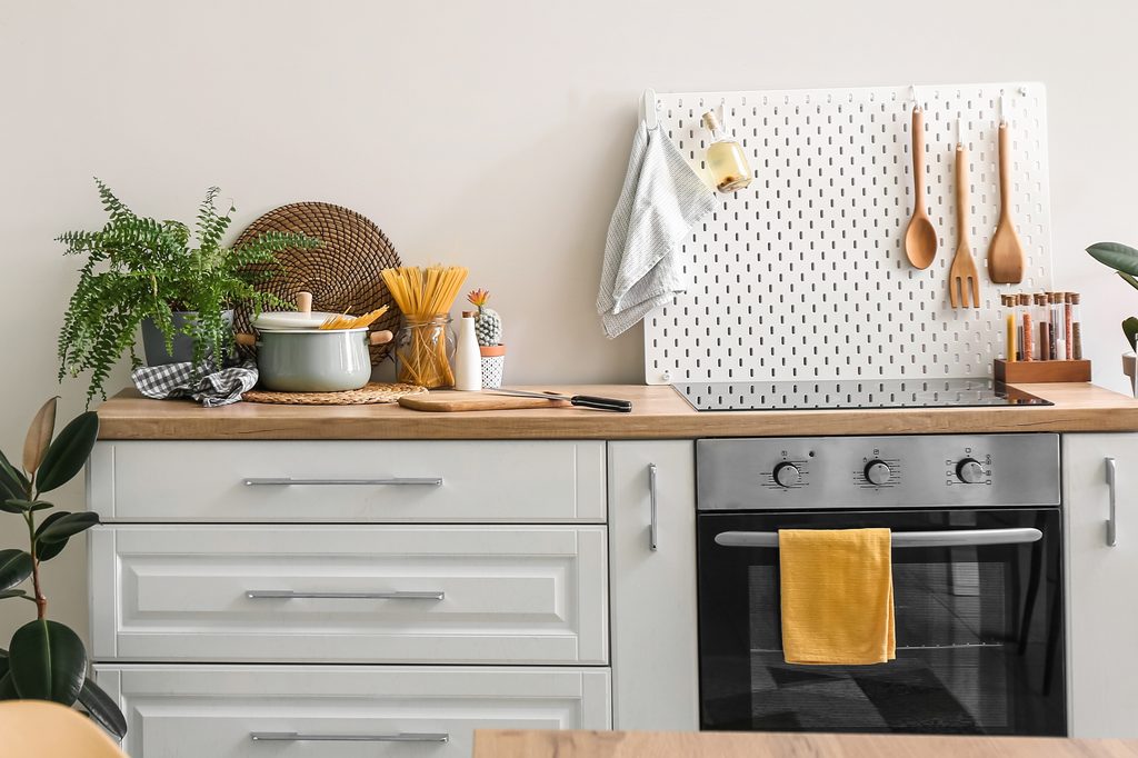 small kitchen with wood countertop and pegboard wall