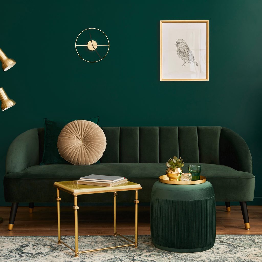 Living room with dark green walls and couch.