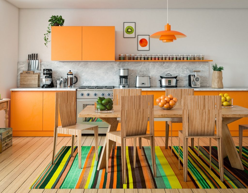 Orange and wood kitchen cabinets in brightly colored kitchen