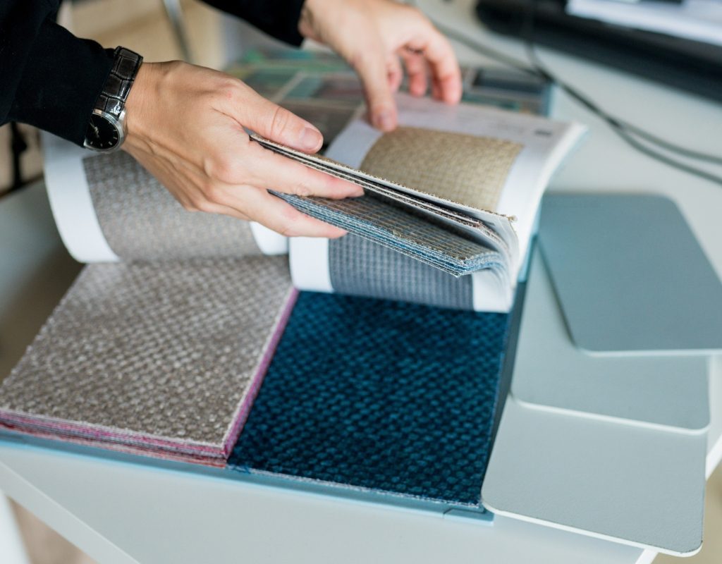 Person flipping through texture swatches for home design
