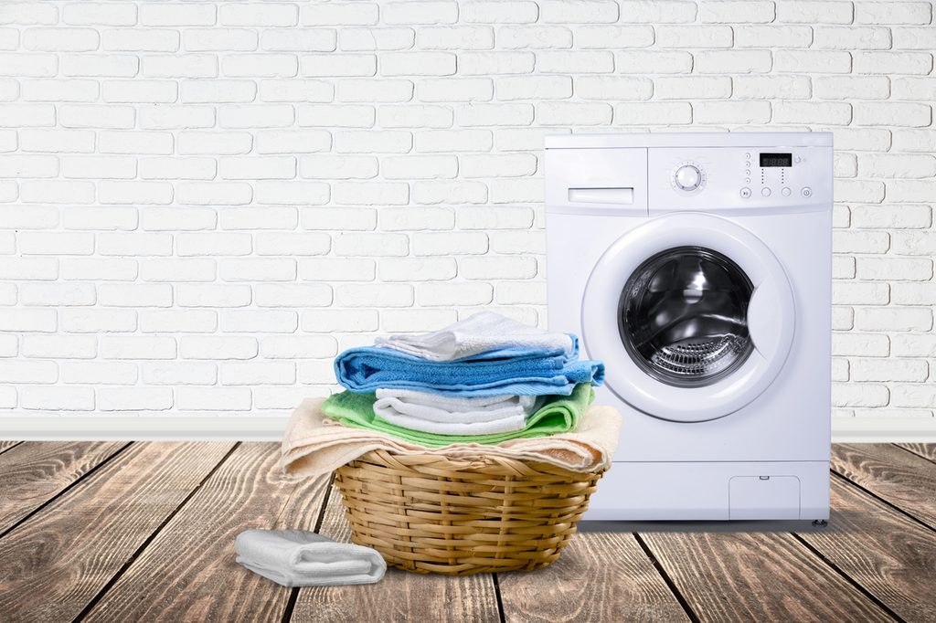 Wicker laundry basket with multi-colored towels in laundry room