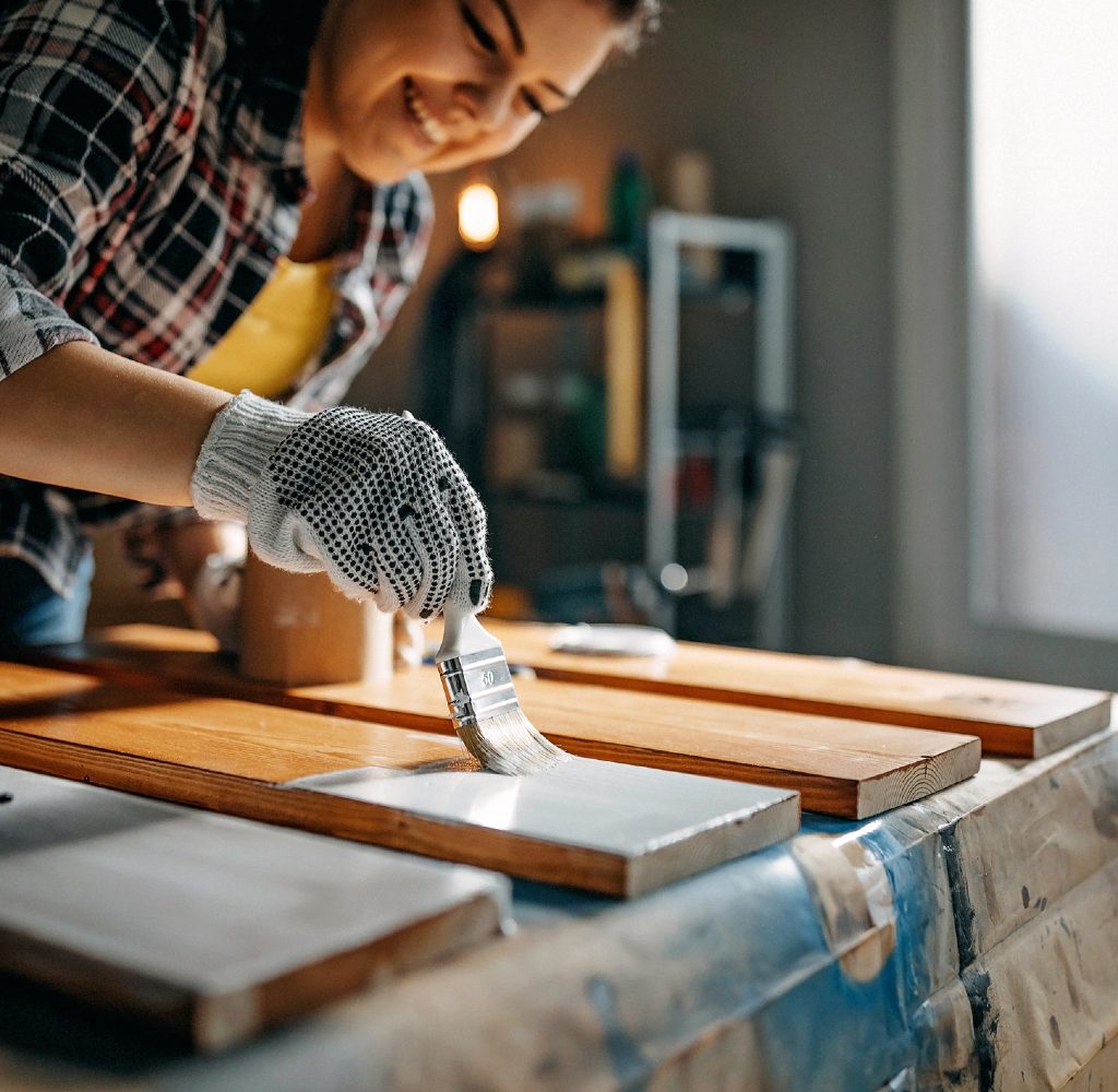 Woman painting wood inside.