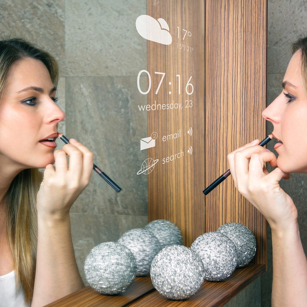 Woman putting on makeup in a smart mirror