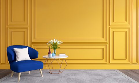 Yellow wall molding with blue chair and a modern aesthetic