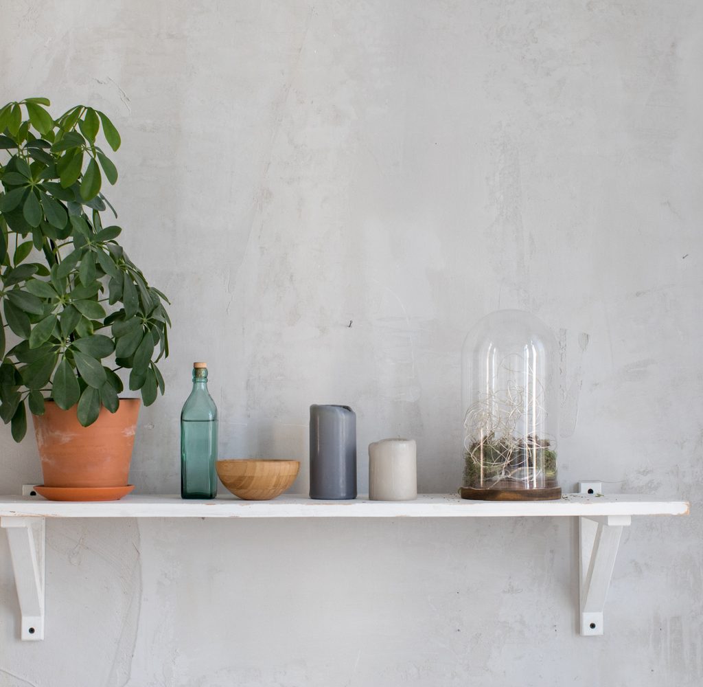 Bathroom floating shelves wit plant and candles.