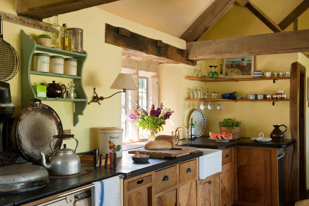 cluttered cottage kitchen design with rustic beams