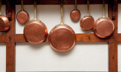 copper cookware pros and cons row of vintage pans  different size hung on wooden