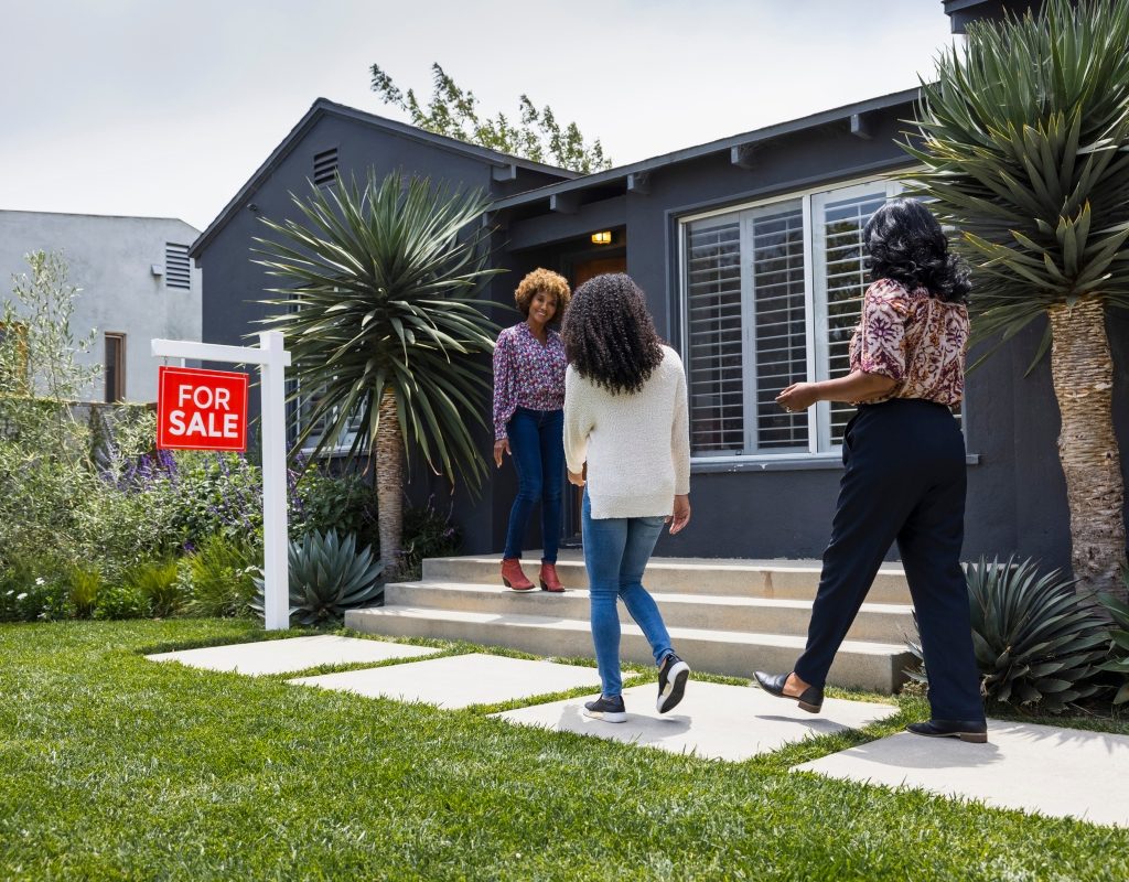 people attending a home showing with for sale sign
