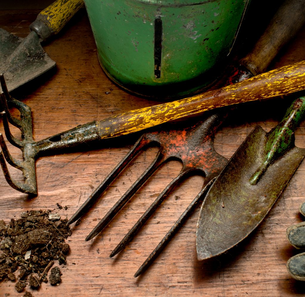 Dirty garden tools on work bench with dirt
